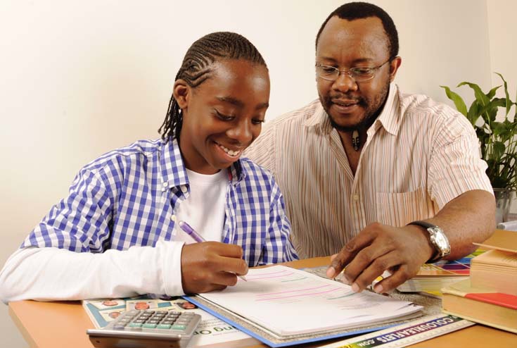 Man helping teenage boy with homework